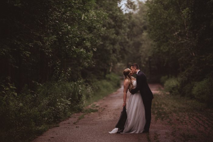 wedding photo of bride and groom romantic kiss on abandoned road